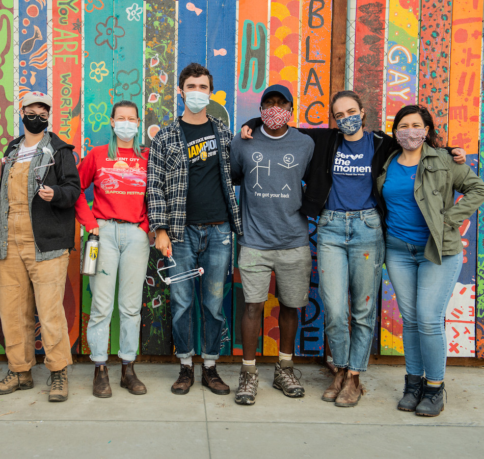 Volunteers paint at a local service partner