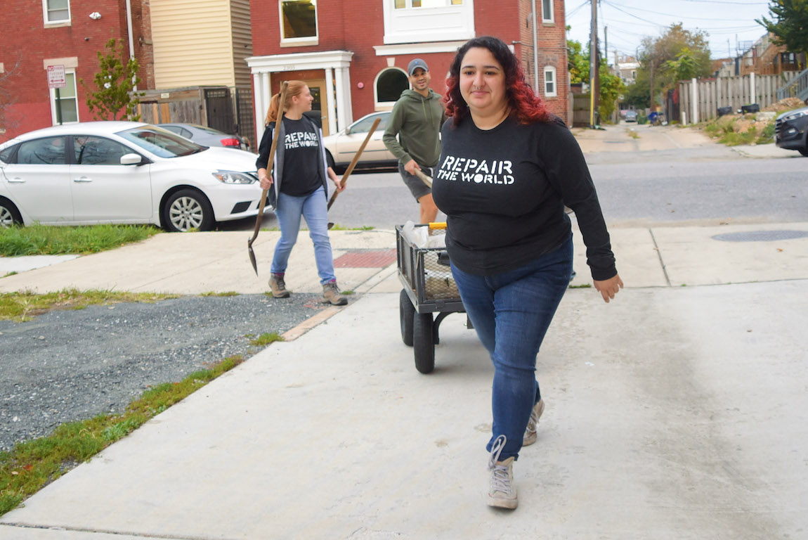 Repair fellow pulls cart while volunteering