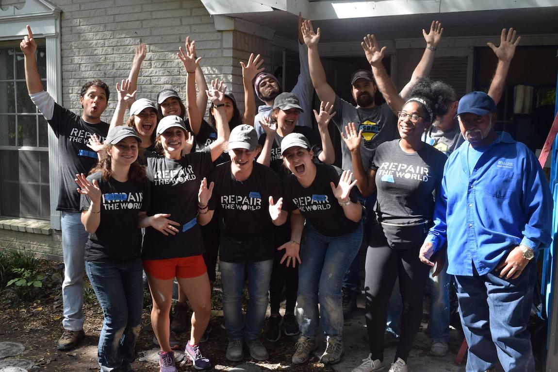 group of volunteers raise hands